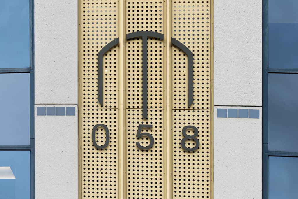 Geveldetail van Lange Marktstraat 058 in Leeuwarden met huisnummer op een geperforeerd paneel.