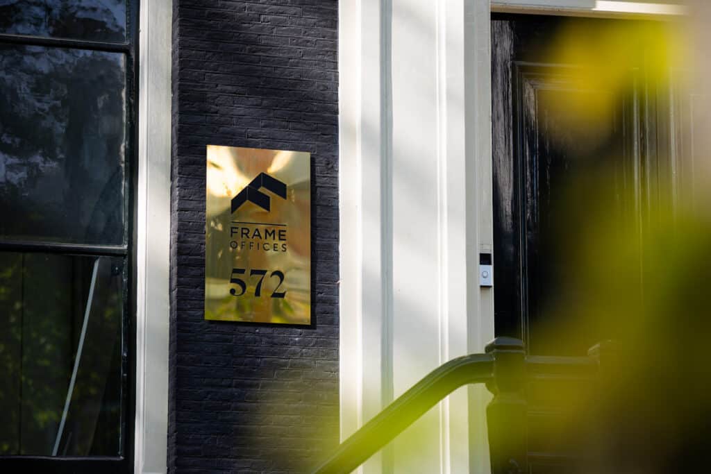 Vooraanzicht Frame offices keizersgracht met gouden welkomstbord.